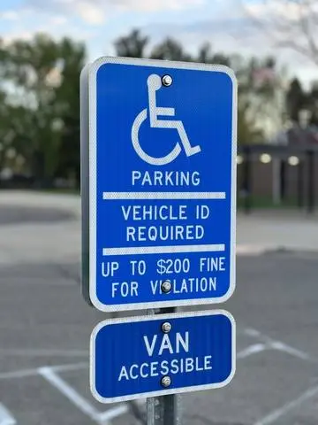Blue accessible parking sign with wheelchair symbol, vehicle ID required and VAN ACCESSIBLE plaque