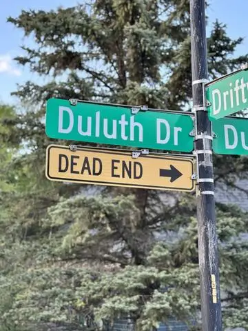 Green street sign reading Duluth Dr with a DEAD END plaque and arrow below