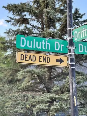 Green street sign reading Duluth Dr with a DEAD END plaque and arrow below