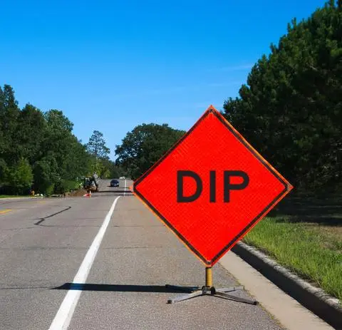 Orange diamond construction sign reading DIP placed on the roadway