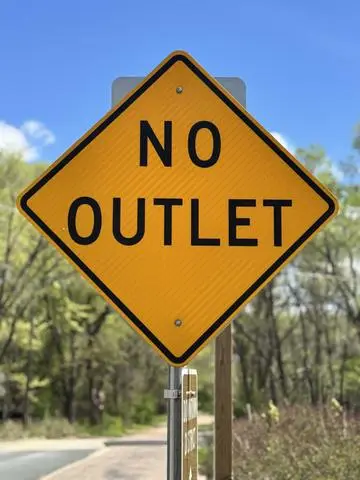 Yellow diamond sign reading NO OUTLET