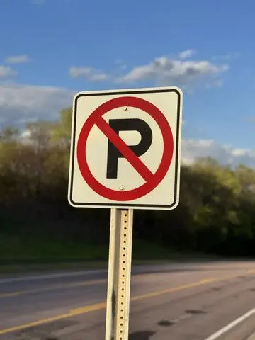White square sign with a letter P crossed by a red circle and slash
