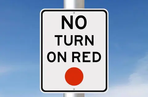 White sign reading NO TURN ON RED with a red circle