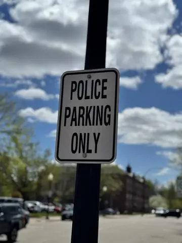 Small white sign reading POLICE PARKING ONLY on a black post