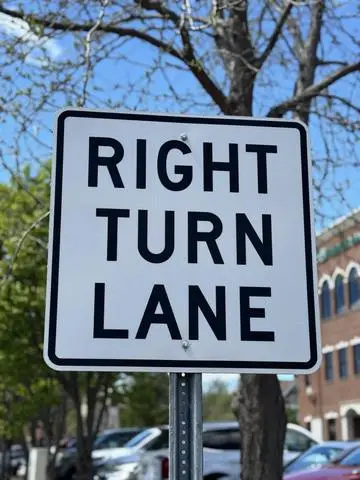 White regulatory sign reading RIGHT TURN LANE