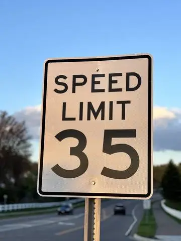 White rectangular SPEED LIMIT 35 sign beside a divided road