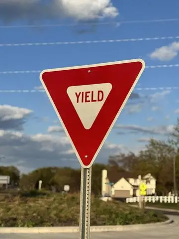 Red and white triangular YIELD sign in a residential area
